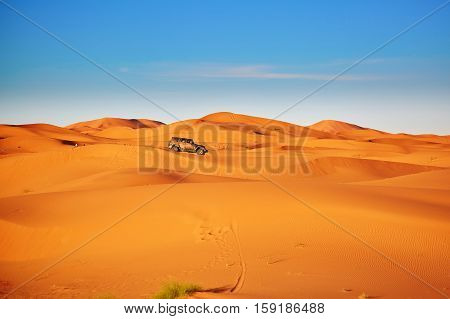 Car In Sand Dunes In The Sahara Desert, Morocco