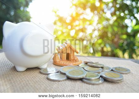 piggy bank with a coin on old wood bokeh background.concept save money