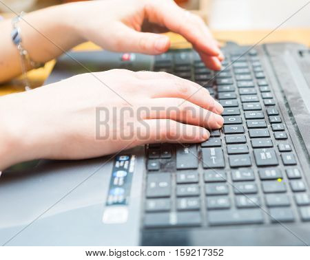 Woman working on laptop keyboard hands close up. Laptop computer keyboard and woman hands