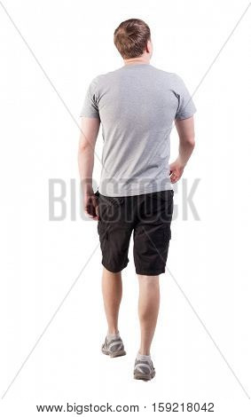 Back view of walking handsome man in shorts and sneakers.  backside view of person.  Isolated over white background. broad-shouldered guy is looking forward to the left