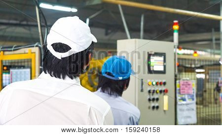 industrial machine and technician concept - Blurred control box unit with asian man technician checking in factory and copyspace