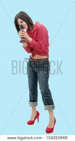 pretty young woman holding cordless drill on blue background