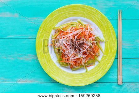 Fresh diet fitness salad of daikon radish carrots flax seeds arugula. Vegan cuisine. The top view