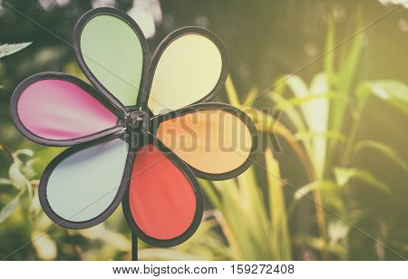 Colorful rainbow toy turbine in garden vitnage tone
