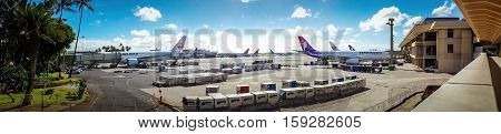 Hawaii, USA - Dec 22, 2015: Panorama of Honolulu International Airport, with various planes docked to their respective jetways.