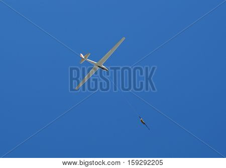 propeller-driven airplane is towing a glider in the sky