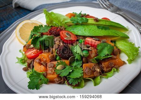 Salad with baked sweet potatoes avocados lentils dried tomatoes cilantro pumpkin seeds and oil. Perfect for the detox diet or just a healthy meal. Love for a healthy raw food concept.