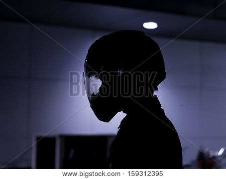 motorcyclist biker rider  wearing helmet in shadow