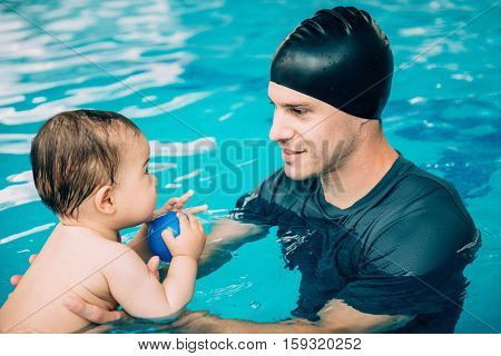 Instructor with cute baby boy on swimming class