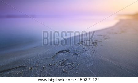 Early morning. Footprints in the sand along the seashore.