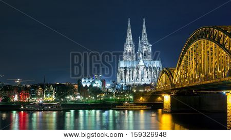 Riverside view of the Cologne Cathedral and railway bridge over the Rhine river Germany