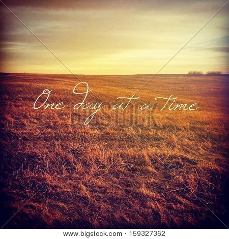 Inspirational quote on scenic field landscape with bright sky, orange grass and isolated bushes at sunset.  Peaceful prairie sunset field landscape view. Bright sky. Instagram effects.