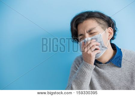 man is coughing isolated on blue background asian