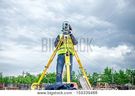 Surveyor engineer is measuring level on construction site. Surveyors ensure precise measurements before undertaking large construction projects.