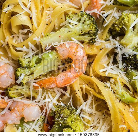 Close-up of pasta linguine with shrimps, broccoli, tomatto and cheese. Top view.
