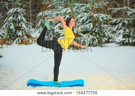 Beautiful Woman Doing Yoga Outdoors In The Snow