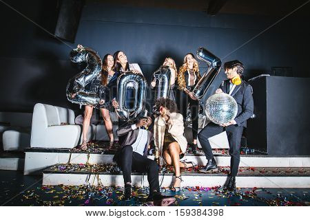 Multi-ethnic group of friends celebrating the end of the year in a nightclub - Sylvester party clubbers having party on new year's eve
