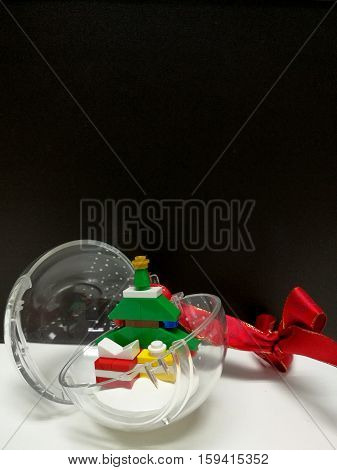 Merry Christmas and Happy New Year colorful Xmas tree and tiny gift box toy decoration in the clear ball on the vertical side