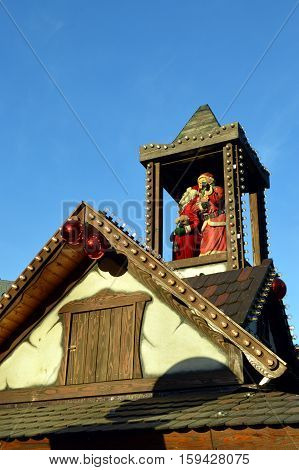 Mom and papa christmas on a wooden tower on a cottage