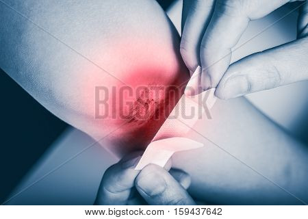 Mother Provides First-aid At Wound On Son Leg With Red Spot Sore Area.
