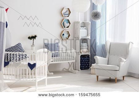 Nursery With White Chair And Cradle