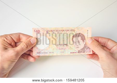 Man Holding Fifty Bhutanese Ngultrum Banknote In His Hands