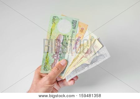 Man Holding A Bunch Of Bhutanese Ngultrum Banknotes In His Hand