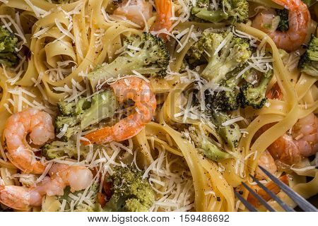 Close-up of pasta linguine with shrimps, broccoli, tomatto and cheese. Top view.