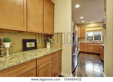 Cloose up of wooden cabinets with granite counter top. Kitchen room with polished hardwood floor. Northwest USA