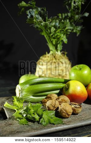 Ingredients for Waldorf salad - celery apples walnotes - fresh and healthy vegetables on granite board.