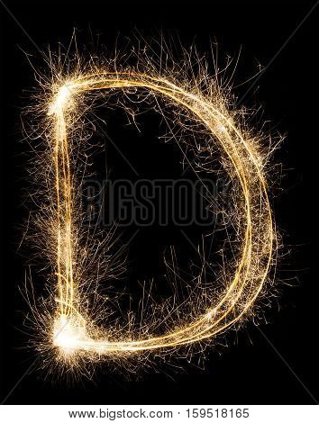English big Letter D made from burning sparkles on black background. Shiny festive party firework font, latin alphabet text sign.