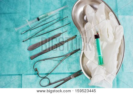 Set of surgical instruments on green gauze