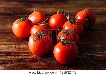 Fresh Red Tomatoes with Water Drops on Wooden Background