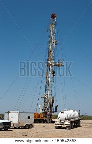 Oil drilling crew called roughnecks work a derrick rig in the oil well fields.