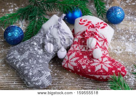 Two Christmas Stockings On Snowbound Wooden Background, Blue Balls