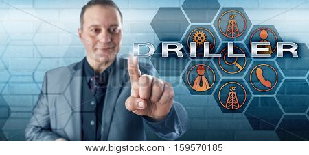 Smiling male oil well team leader with happy facial expression touching DRILLER on a virtual control screen. Oilfield terminology and petroleum industry concept for the drilling supervisor in charge.