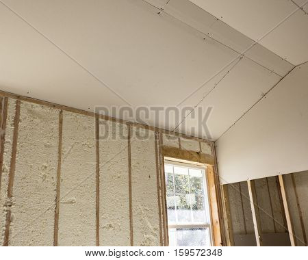 Blown in open cell foam insulation on 2 by 6 studs. with sheetrock on sloped ceiling.