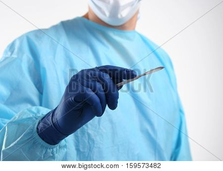 Surgeon hand hold scalpel and tweezers while cut and cure wound closeup. Resuscitation and or, injury heal, medic shop or store, saving patient, 911, surgery and emergency, put stitch concept
