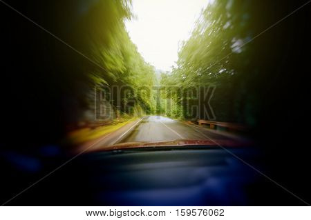 Blurred image of car headlights driving through forest - drunk scarry vision