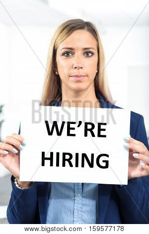 Woman Holding Hiring Sign In A Worklace Bacground