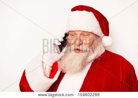 Funny Santa Claus Wearing Red Costume Talking On Phone  While Standing White Background