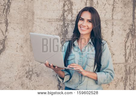 Portrait Of Young Happy Blogger With Modern Laptop Near Stone Wall