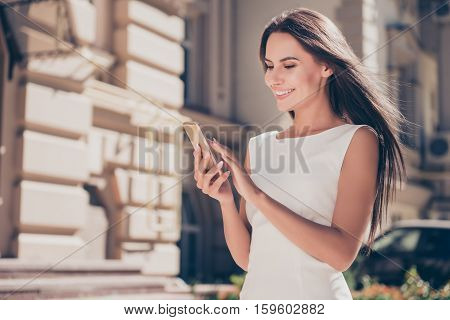 Happy Brunette Woman Typing Sms On Smartphone In City