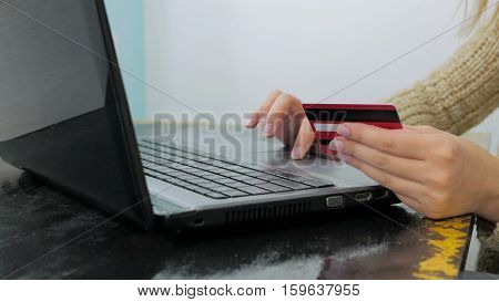 Close up shot. Young woman buying goods from the internet and entering number security code from credit card on laptop. Online, technology and internet concept.