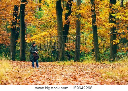 Woman Checking Smartphone On Path In Autumn Forest.