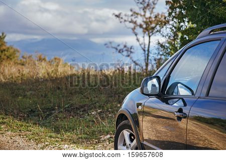 black car on a mountain road on a background of mountains