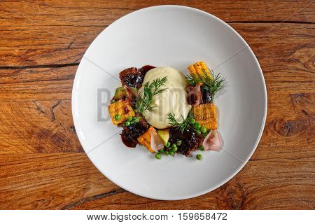 Pulled pork with grilled vegetables on wooden table