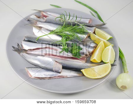 fishes herrings with lemon on a plate