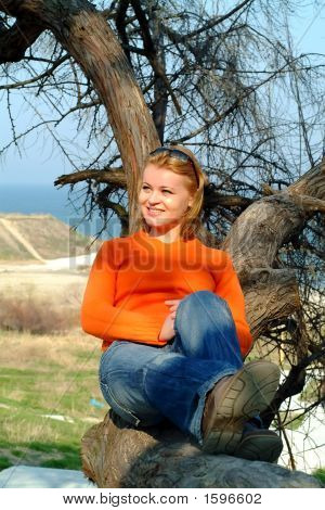 Fille reposant sur un arbre