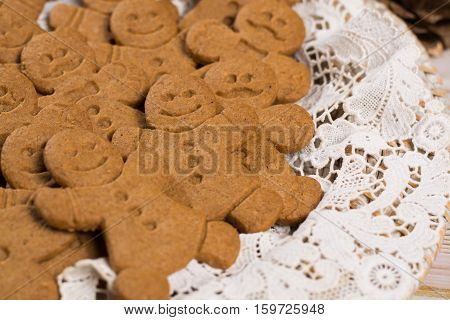 Christmas smiling gingerbread men men and women on white handmade lace with Christmas decoration